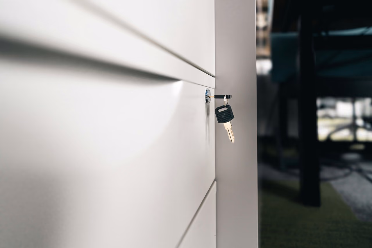 Key in the lock of a white office storage cabinet