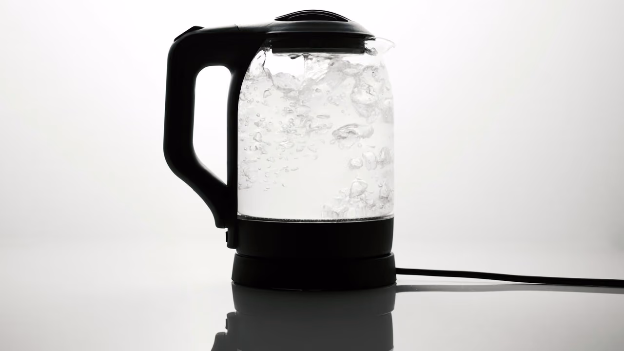 Glass electric kettle boiling water on its base