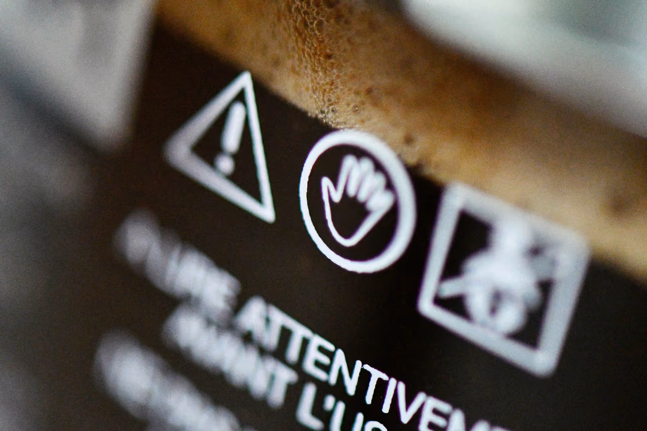 Warning pictograms and the French instruction to read carefully before use on a product label