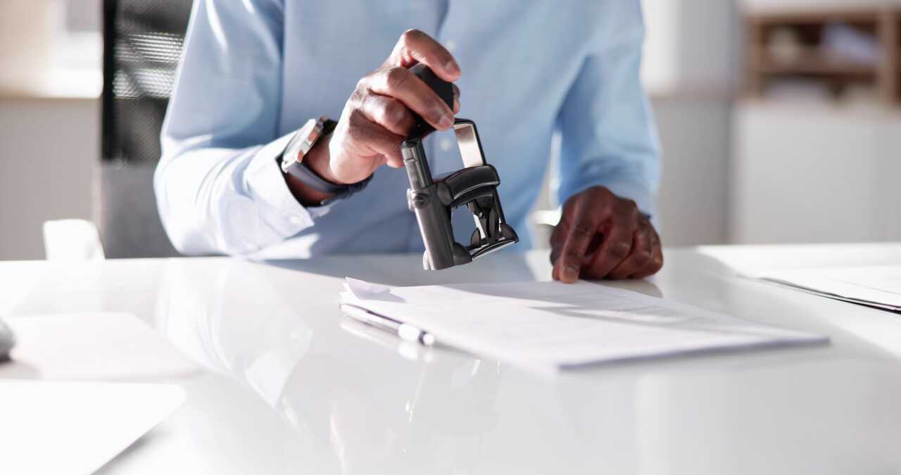 Hand stamping a document on a desk