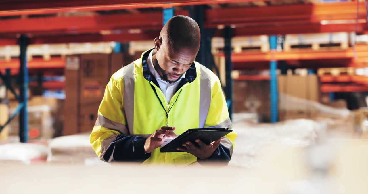 Warehouse employee checking stock on a tablet
