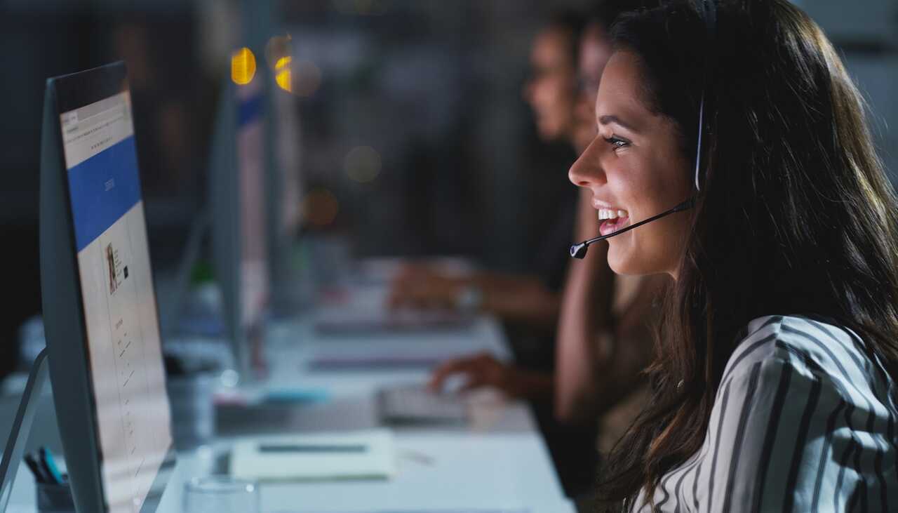 Customer service representative wearing a headset at a screen